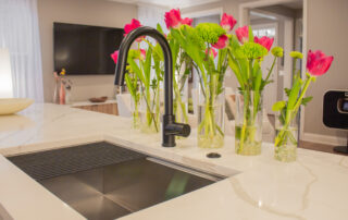 kitchen sink with quartz countertop black faucet and pink tulips behind faucet. from a kitchen remodel frankin tn